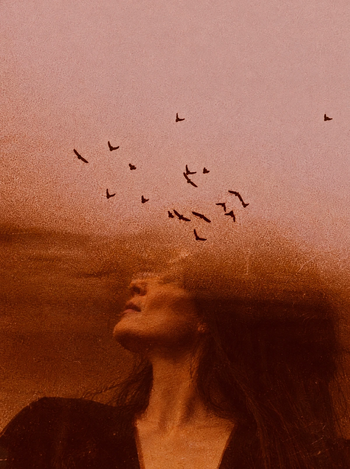 Portrait de Chloé aux tons chauds, avec des oiseaux dans le ciel